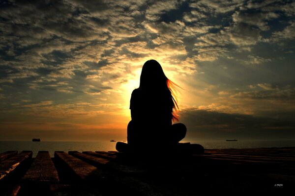 A girl at sunset enjoys the weather