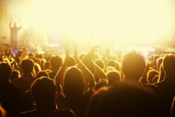 Salle de concert avec des gens dans une lueur jaune