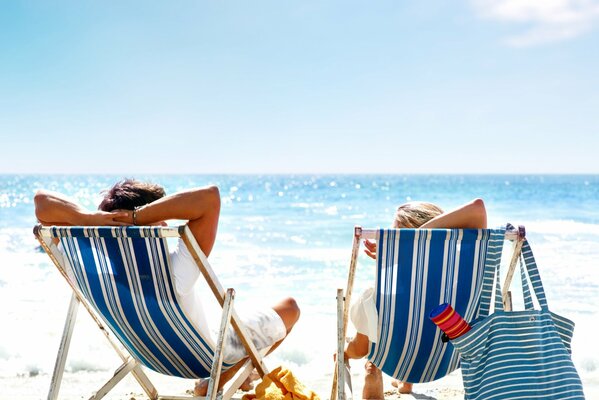 Zwei am Strand ruhen sich in Sesseln aus