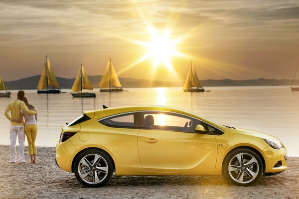 Elegante amarillo en la playa en el coche