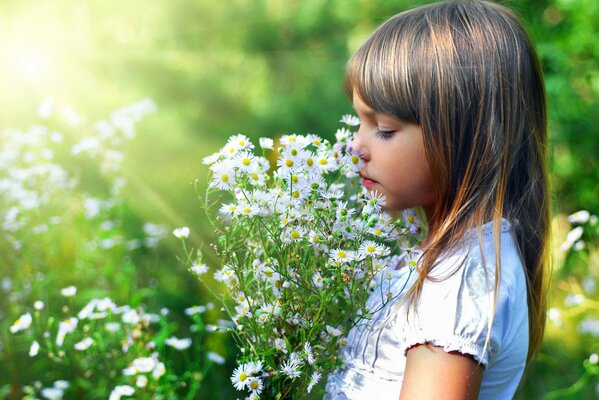 Fille reniflant un bouquet de marguerites