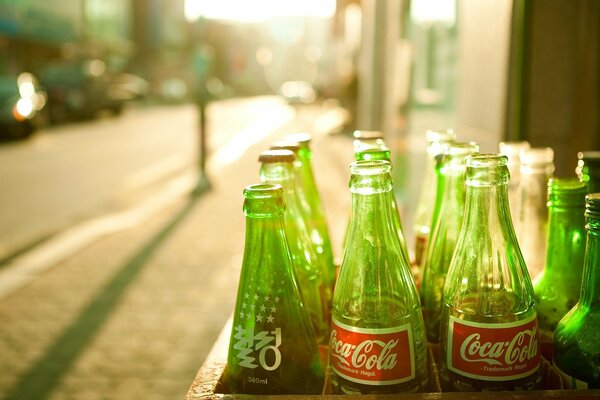 Bouteilles vertes de Coca-Cola au soleil