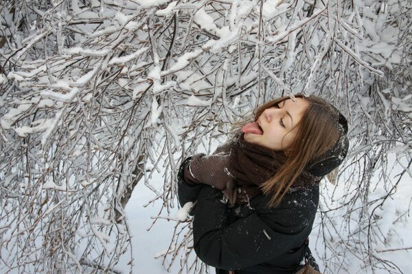Dziewczyna łapie śnieg językiem