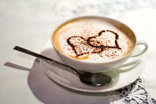 Café con corazón en una taza blanca sobre la mesa