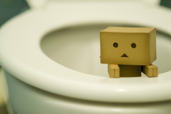 A small yellow funny figure in the toilet