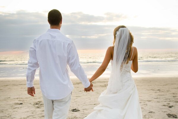 Photo de mariage sur la plage. Jeunes mariés
