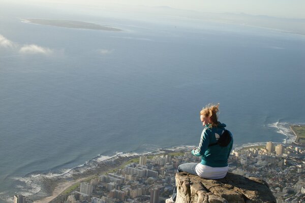 Fille assise sur le bord d une haute falaise