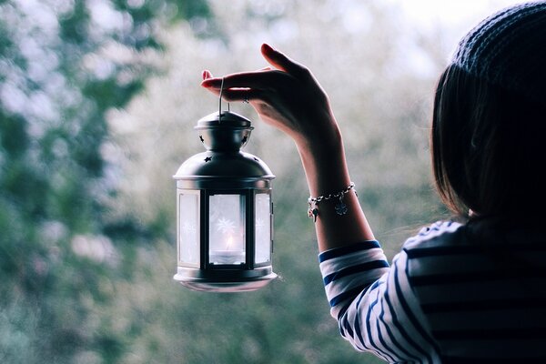 The lantern in the girl s hands illuminates the way to a good mood
