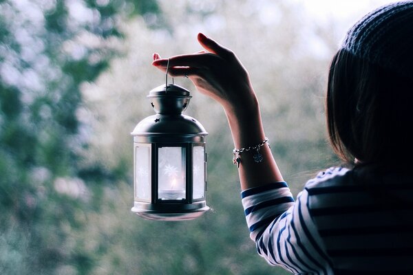 Lanterne dans les mains de la jeune fille illumine le chemin de la bonne humeur