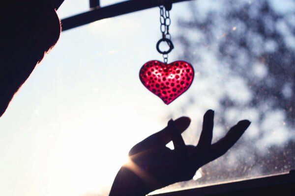 Porte-clés en forme de coeur rouge dans la main