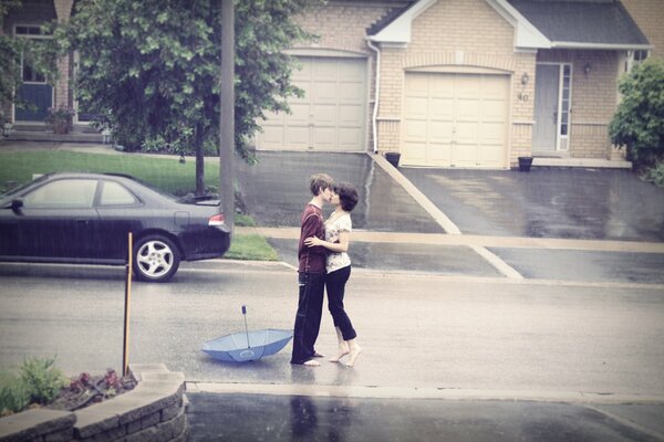 A kiss in the rain without an umbrella on the road