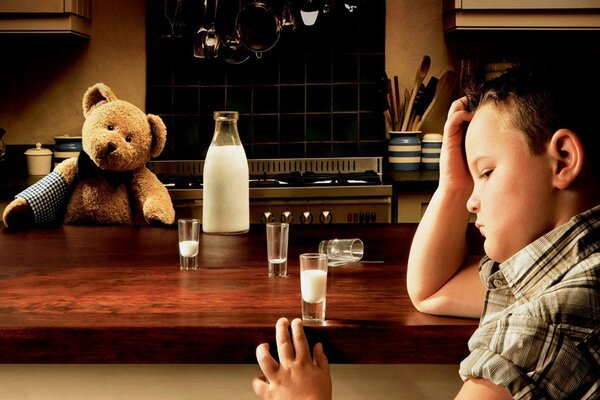 Enfant triste avec un ours et du lait