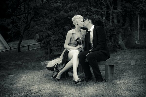 A couple in love on a bench in dark colors