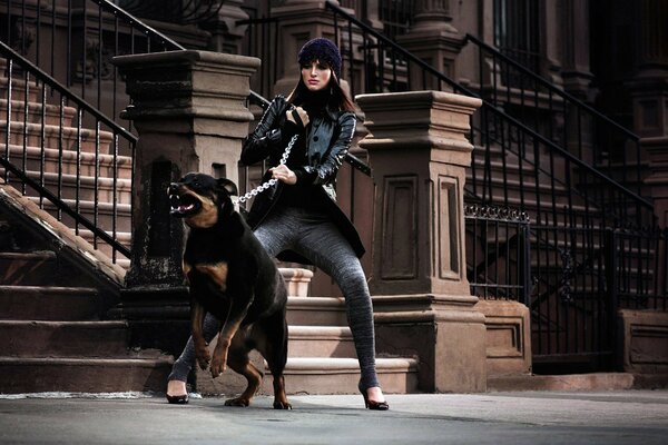 A girl restrains an aggressive dog