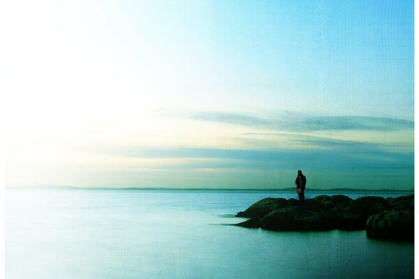 Ein einsamer Mann steht in der Ferne am Meer