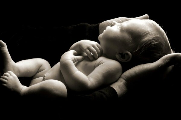 Black and white image of a baby in his hands