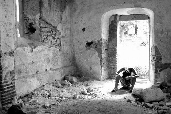 A girl among ruins and dust in black and white style