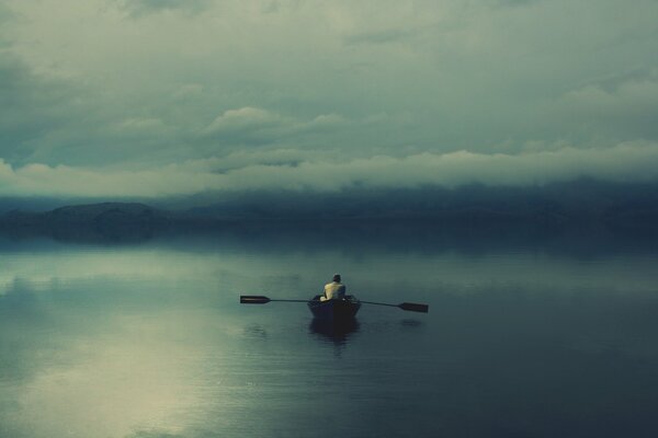 Homme seul dans un bateau sur le lac