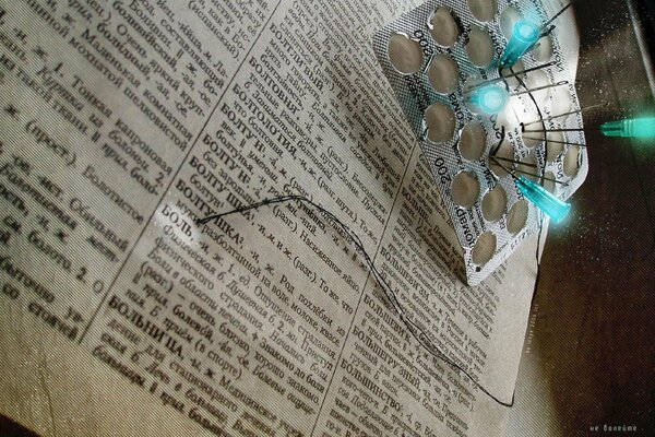 Empty blister with inserted needles on the page of the medical dictionary