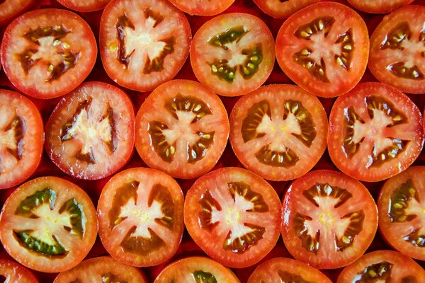 Los tomates cortados a la mitad se encuentran exactamente en filas