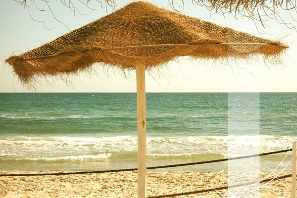 Parasol au bord de la mer dans le sable