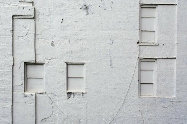 Ventanas cerradas en un antiguo edificio blanco