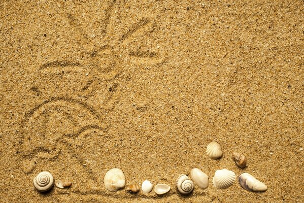 Painted sun on sand and shells