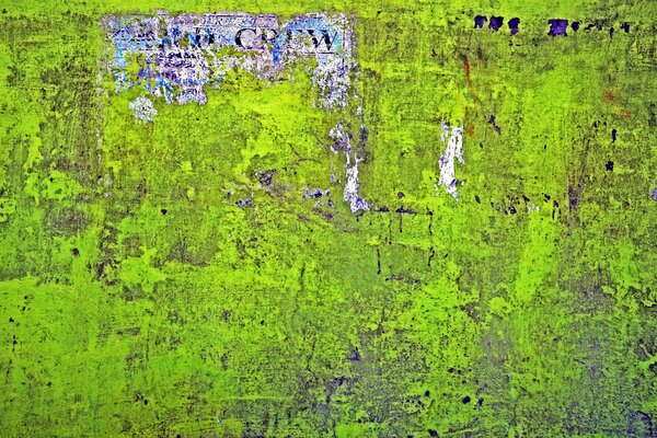 Zielona ściana z rozdartym postrzępionym plakatem