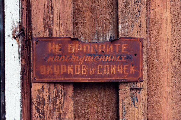 A rusty sign with an inscription on the wall