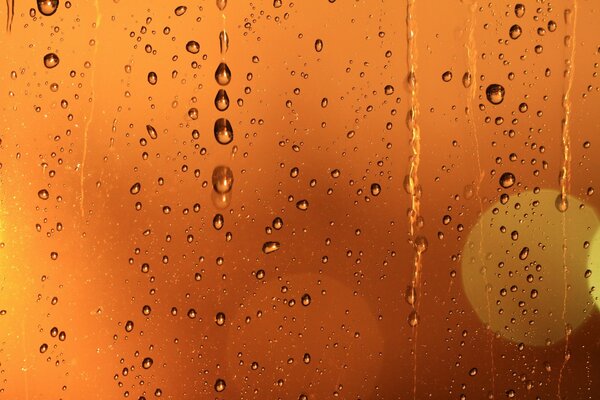 Die Laternen brechen durch das vom Regen nasse Glas