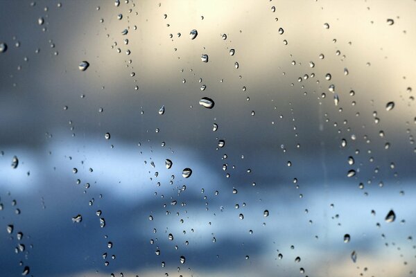 Viele Tropfen auf dem Glas und dahinter der Himmel