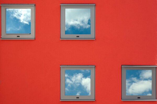 Petites fenêtres carrées sur le mur rouge
