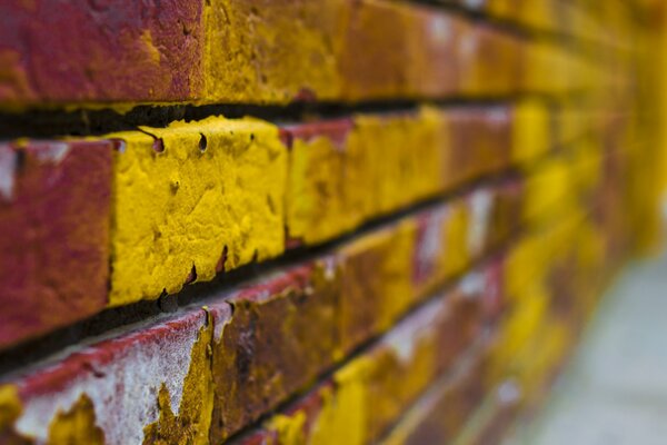 Red brick wall with yellow paint