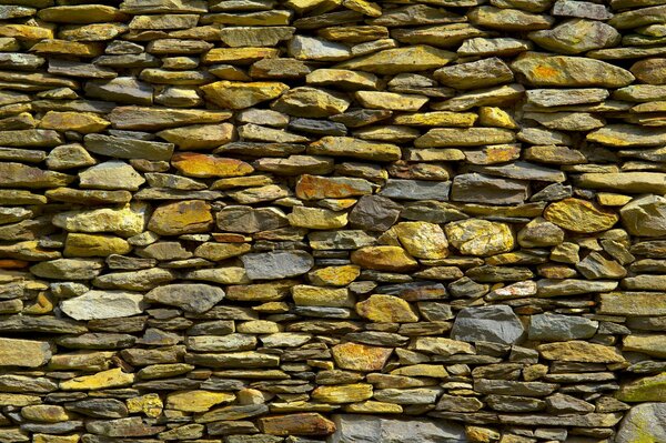 A wall of yellow, white and gray stones