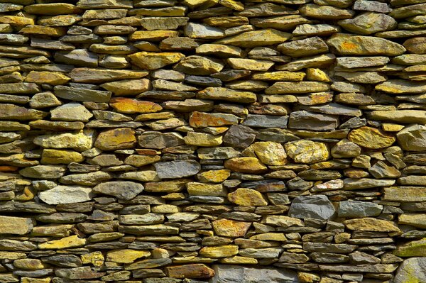 Muro di pietre gialle, bianche e grigie