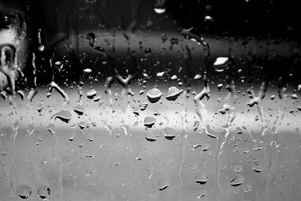 Gotas de lluvia en un cristal gris de otoño