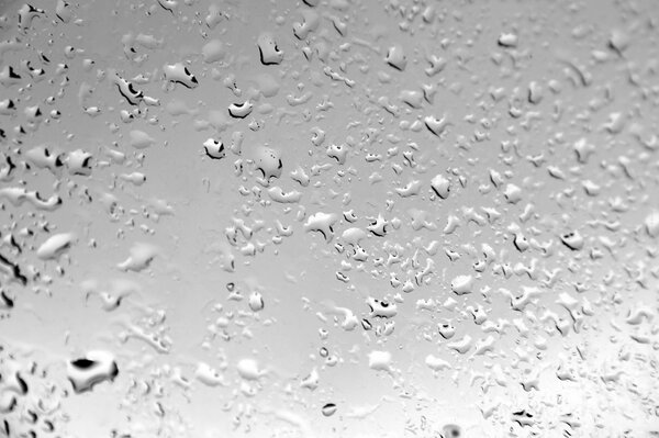 Капли воды в дождь на стекле
