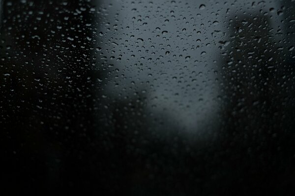 Raindrops on the glass on a dark background