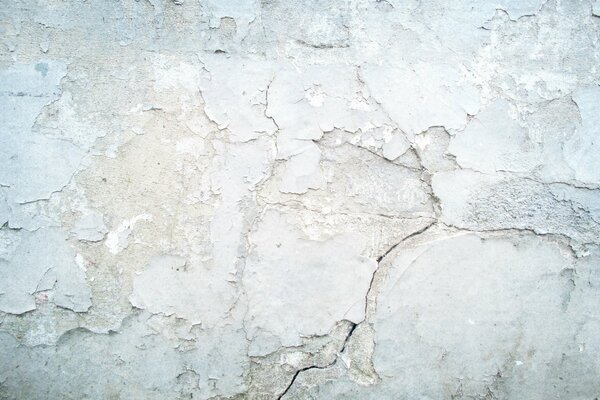 The texture of peeling paint on a gray wall background