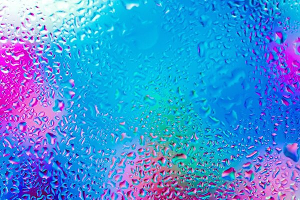 Water drops on glass on a multicolored background