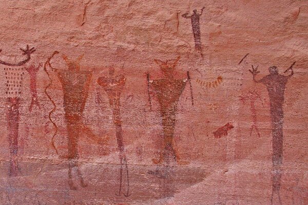 Peinture rupestre avec des gens avec les mains levées