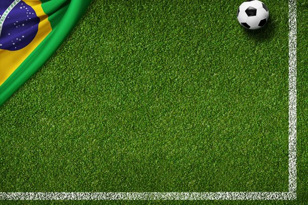 Ballon de football et le drapeau du Brésil sur la pelouse
