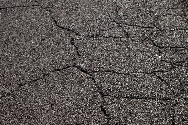 Risse auf der Straße auf der Asphaltdecke