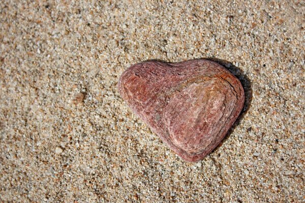 Pietra simile a un cuore sulla riva del mare