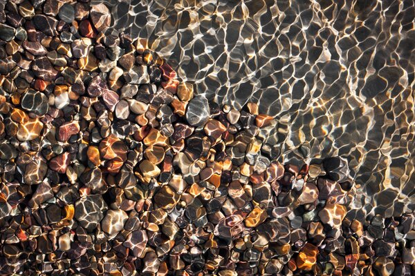 Reflets de l eau sur les galets de la plage