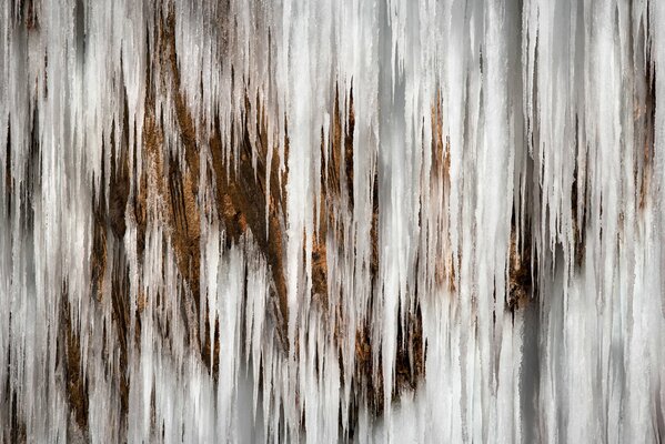 Waterfall of frozen icicles in the rock