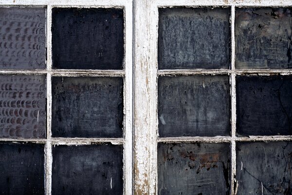 Wooden window with peeling paint and dirt