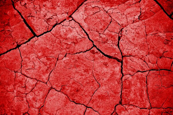 Textura roja contra el fondo de las grietas de la tierra