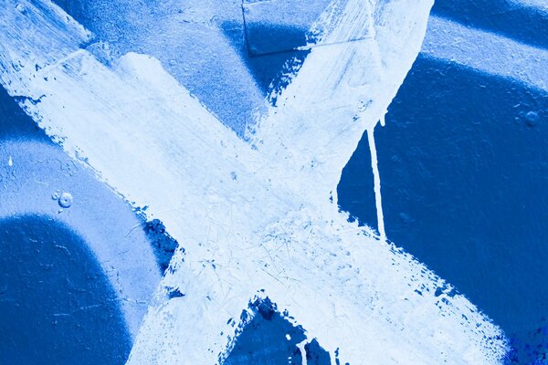 White cross with a brush on a blue wall
