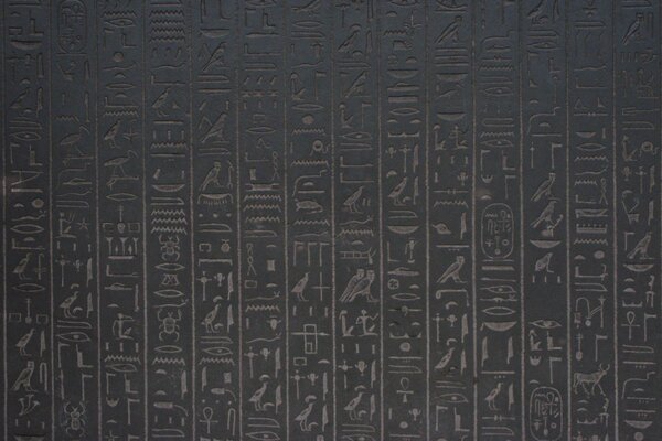 Ägyptische Hieroglyphen an einer braunen Wand